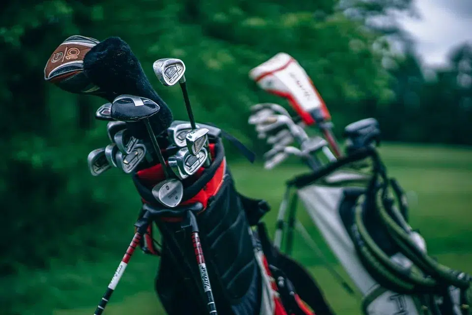 two bags of golf clubs are standing on the field each other to choose the right golf club for beginners